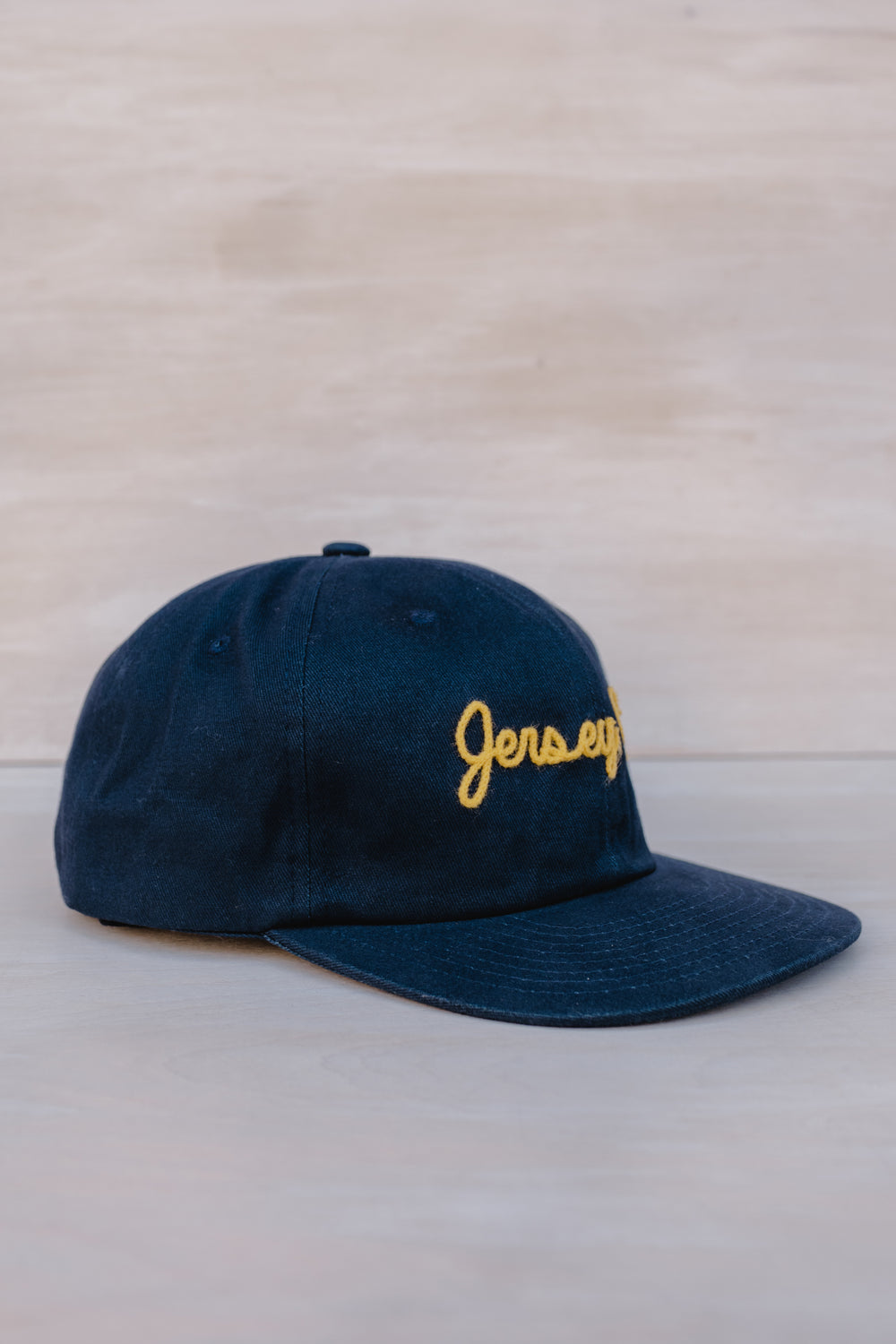 Weld MFG Jersey City embroidered hat in navy blue with yellow stitching for stylish wear