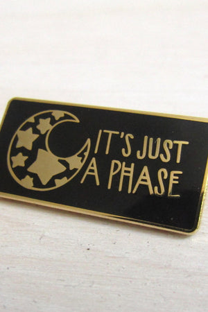 black and gold rectangle pin with illustration of mood with stars inside it.