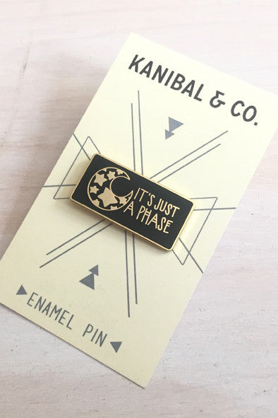 black and gold rectangle pin with illustration of mood with stars inside it on cardstock