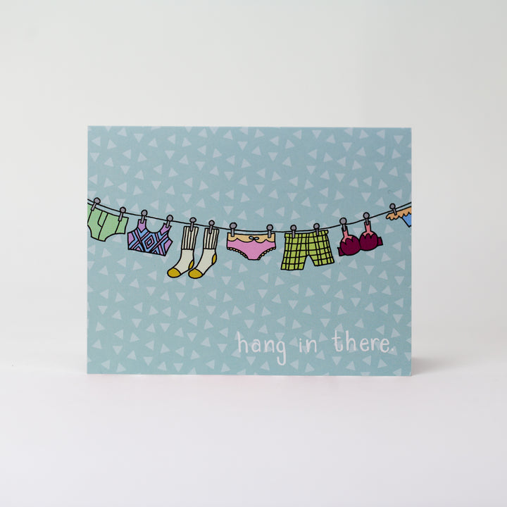 Kanibal & Co. encouragement greeting card with colorful clothes hanging on a line and hang in there message