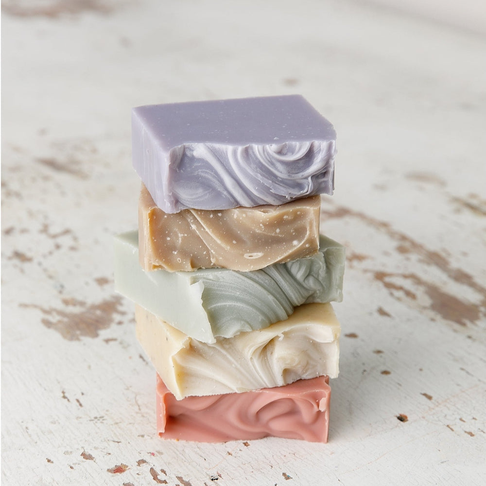 Stack of Old Whaling Co French lavender bar soap and assorted scented bar soaps with textured swirls