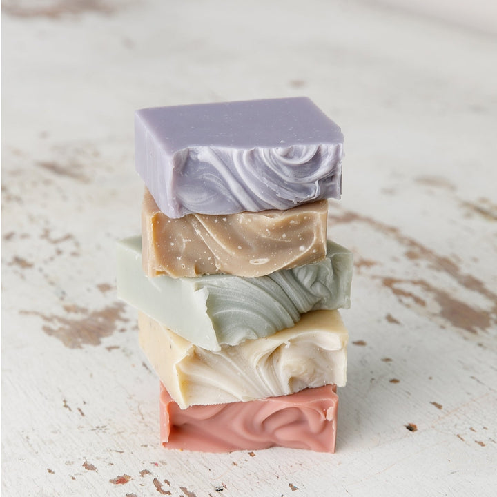 Stack of Old Whaling Co French lavender bar soap and assorted scented bar soaps with textured swirls