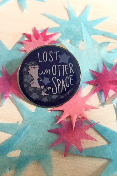 blue round pin with illustration of otter on top of star cut outs