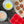 Red silicone doughnut pan with baked doughnuts and bowls of melted butter and flour on wooden table